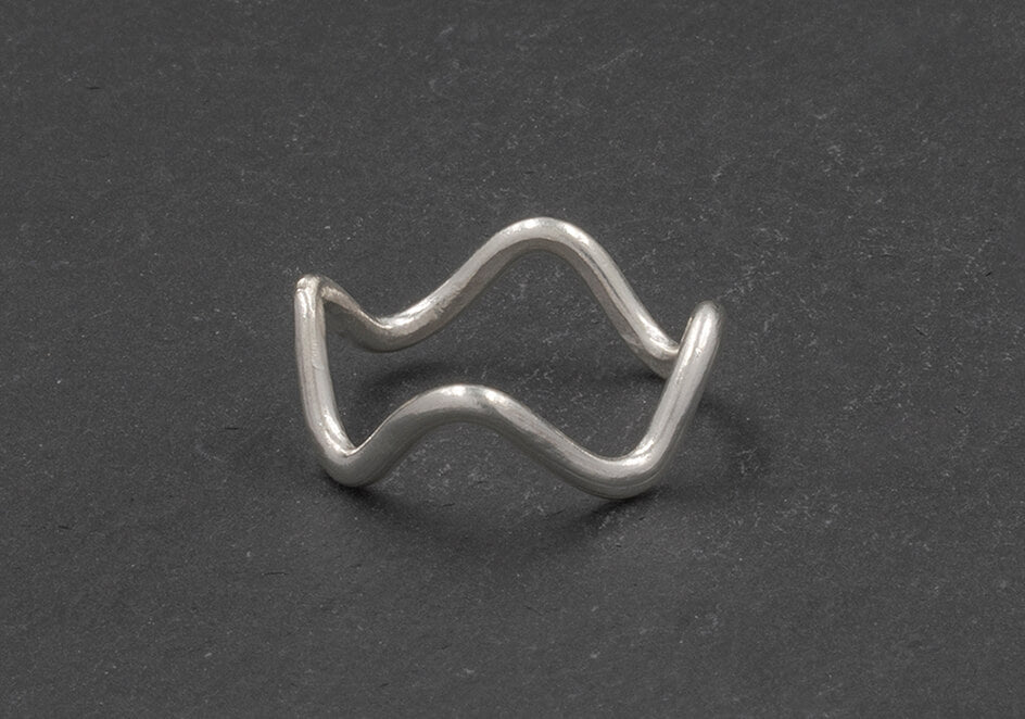 Minimalist wave ring from Hill to Street seating on a dark grey stone