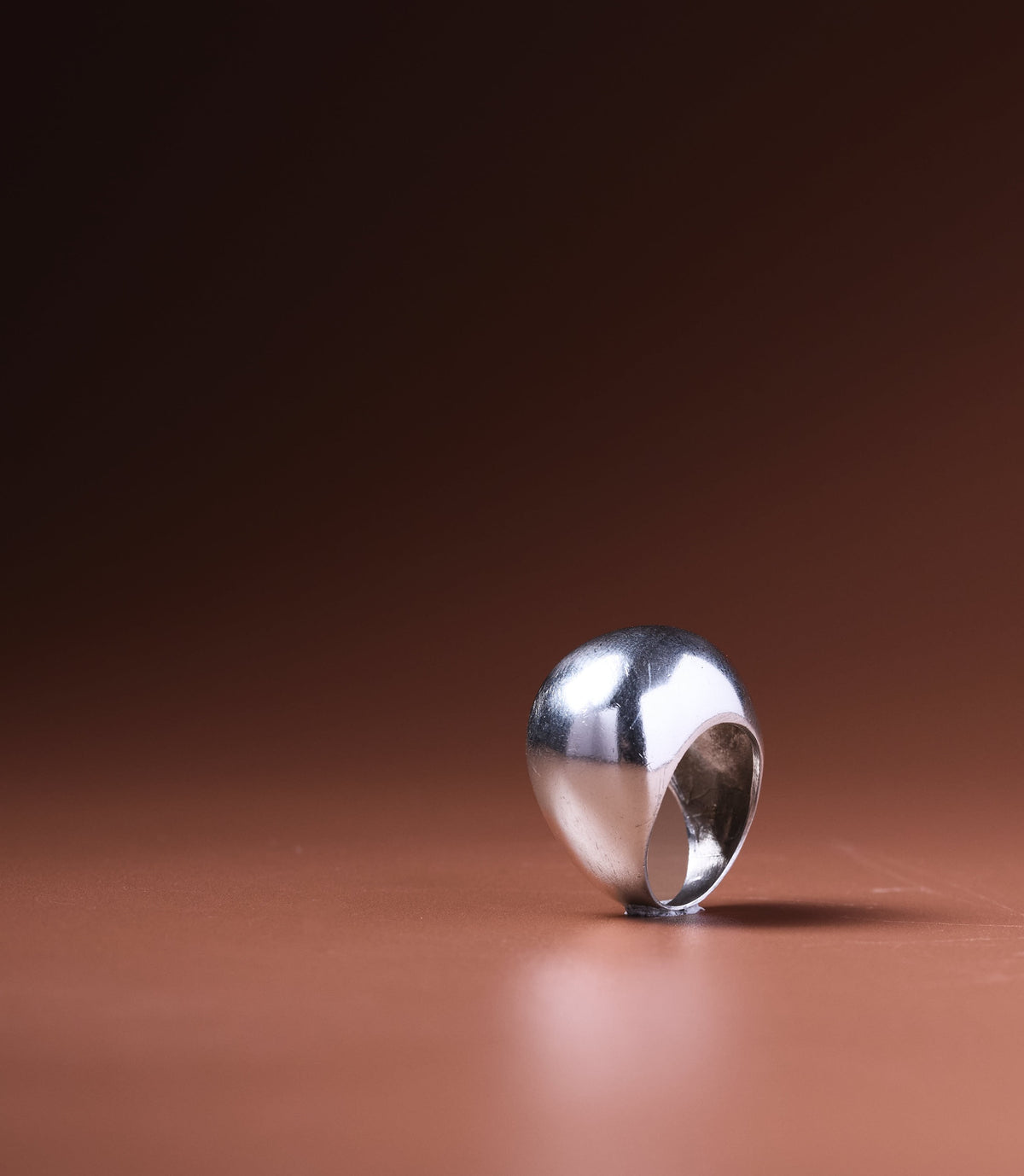 Selene Sterling Silver Statement Ring — handcrafted high-dome 925 sterling silver ring on a warm terracotta background