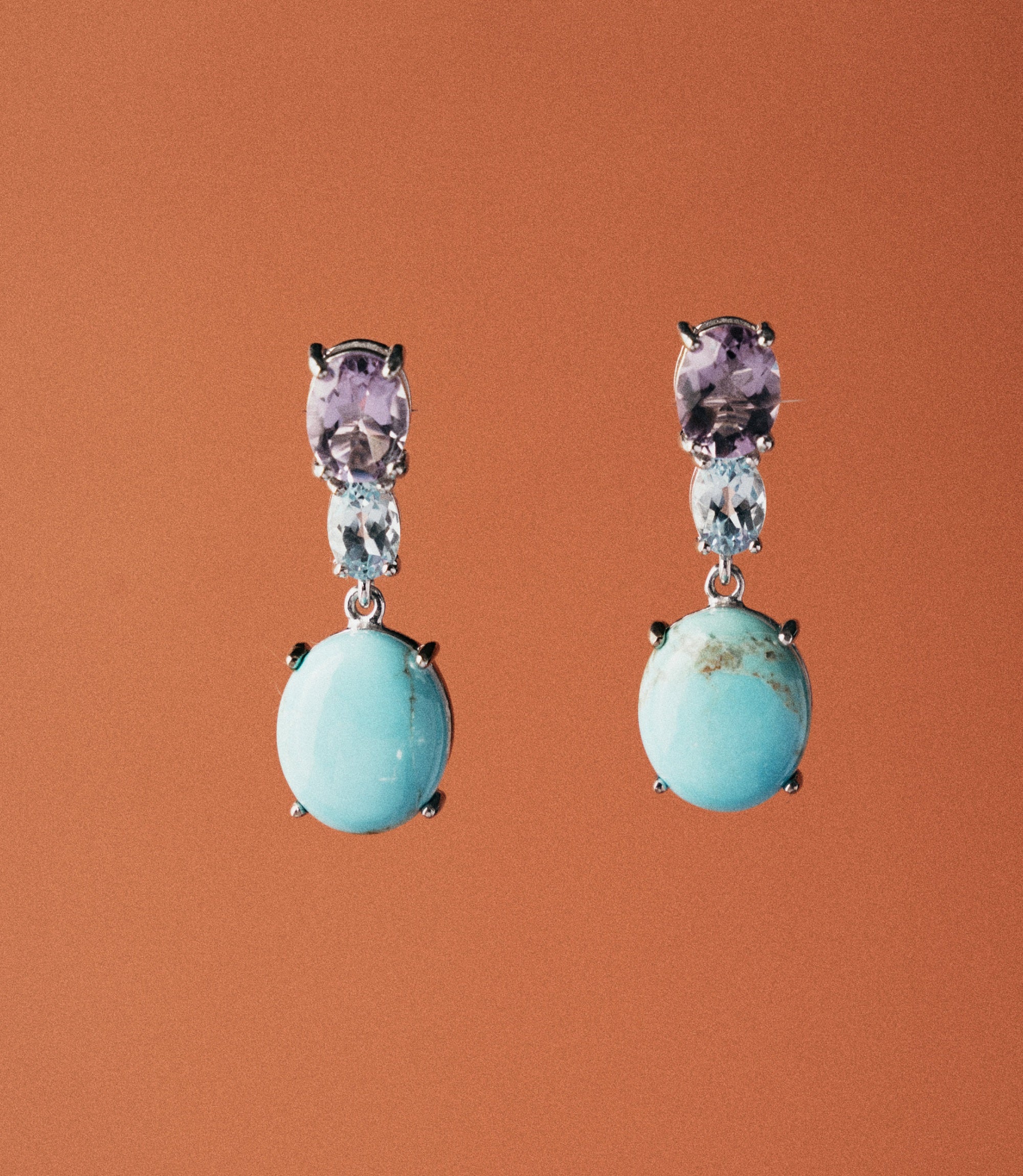 Handcrafted sterling silver 925 drop earrings with synthetic turquoise cabochon and oval amethyst stones. A vibrant, artisan everyday earring.