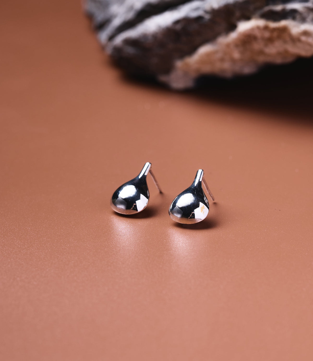Wren Sterling Silver Water Drop Earrings, polished 925 teardrop stud earrings on a neutral surface