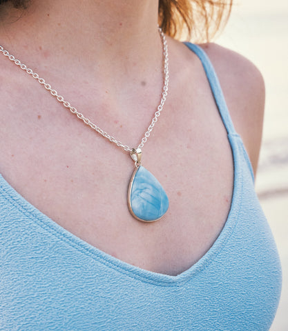 Model wearing the Aurelia Necklace, a statement 925 Sterling silver necklace with a sky-blue stone pendant.