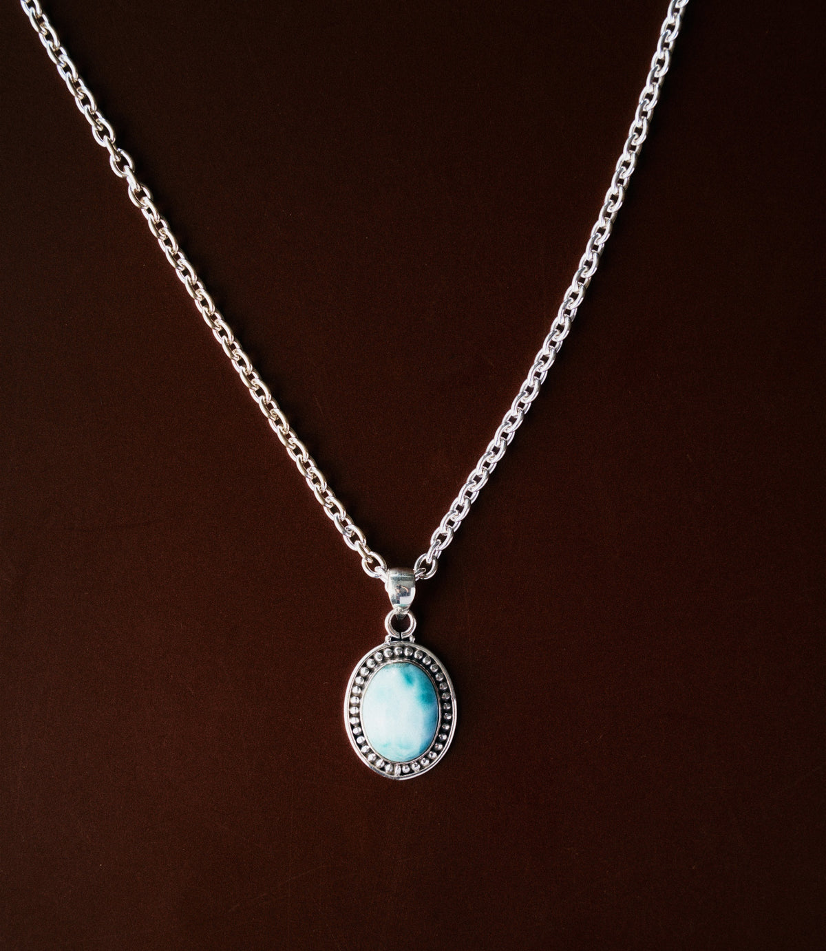 The Celia Necklace in 925 sterling silver featuring an oval synthetic larimar pendant with soft ocean-blue tones.