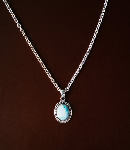 The Celia Necklace in 925 sterling silver featuring an oval synthetic larimar pendant with soft ocean-blue tones.