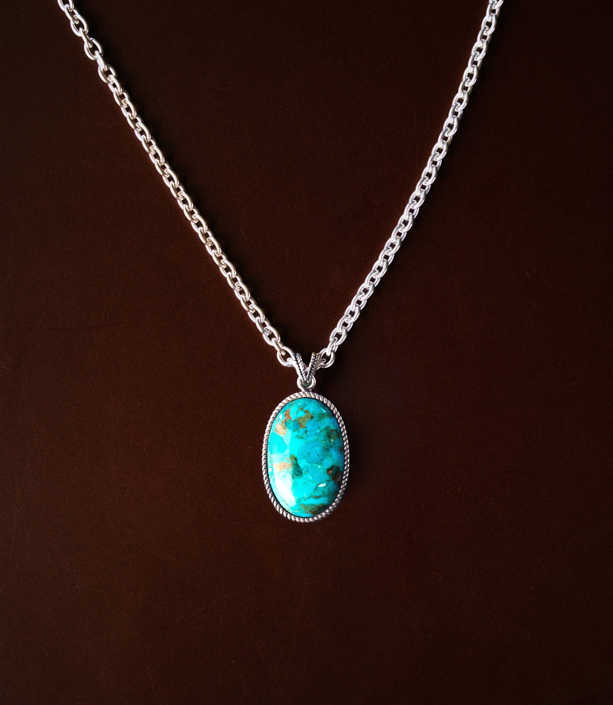 Aurea Necklace in 925 Sterling silver featuring an oval synthetic turquoise stone set in a decorative silver bezel.