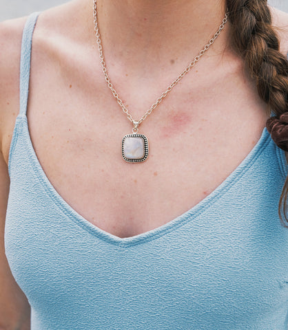 Model wearing the Aveline Necklace, a minimalist 925 sterling silver necklace with a moonstone pendant.