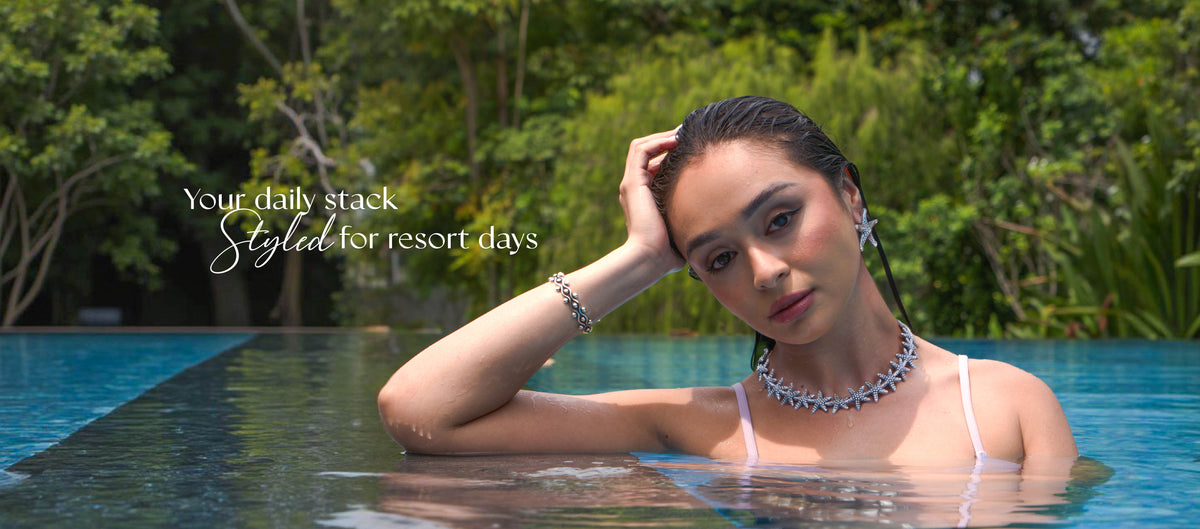 Model in a pool wearing a silver starfish necklace and bracelet: your daily stack, styled for resort days