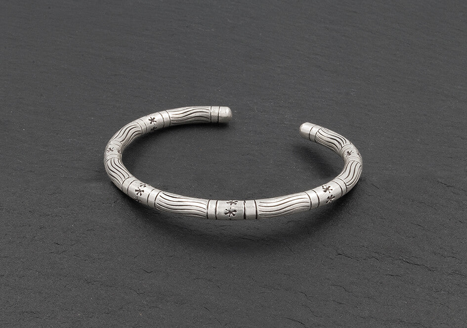 Stars and lines unisex silver bangle from Hill to Street over a grey background