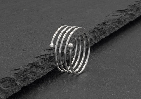 Coil silver ring from Hill to Street over a dark grey background