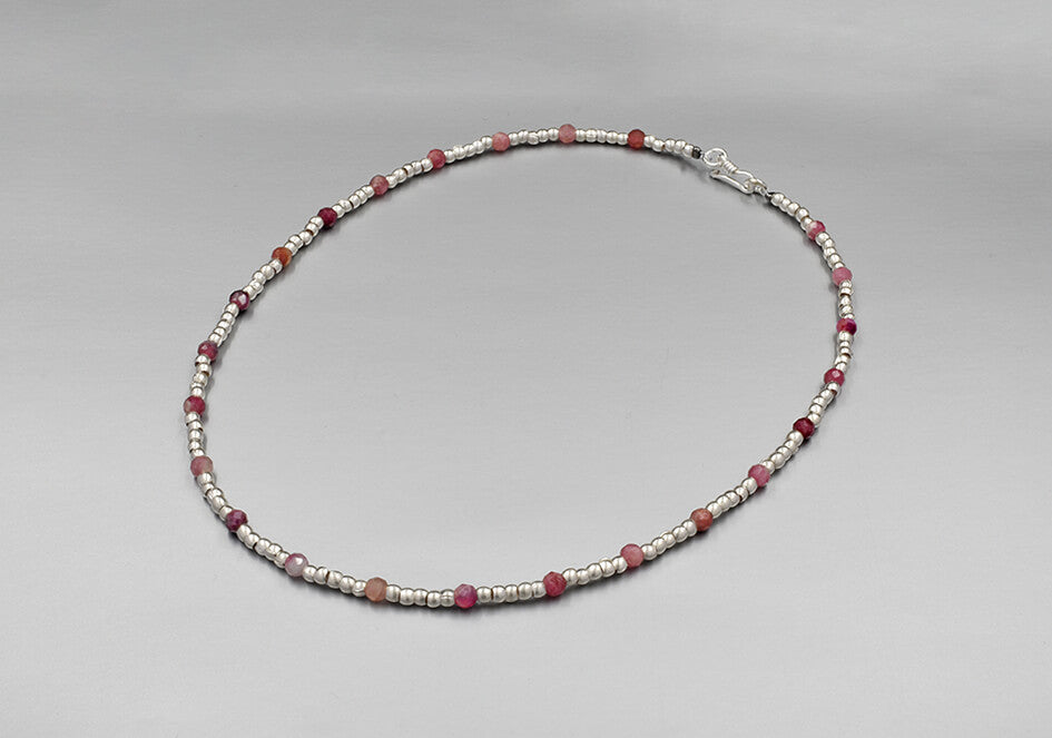 Colour splash beaded necklace with silver beads and pink spinel beads over a play grey background
