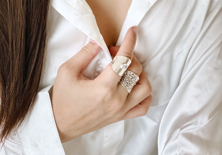 Model wearing a cubic zirconia hammered cuff ring from Hill to Street over a white blouse