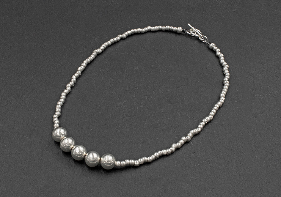 Photo of a double beads silver necklace over a black background