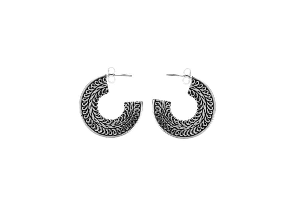 Close-up of the flat sterling silver hoop earrings showcasing the intricate artisan detailing and polished finish.
