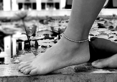 Black and white photo of a model wearing irregular silver beads anklet from Hill to Street