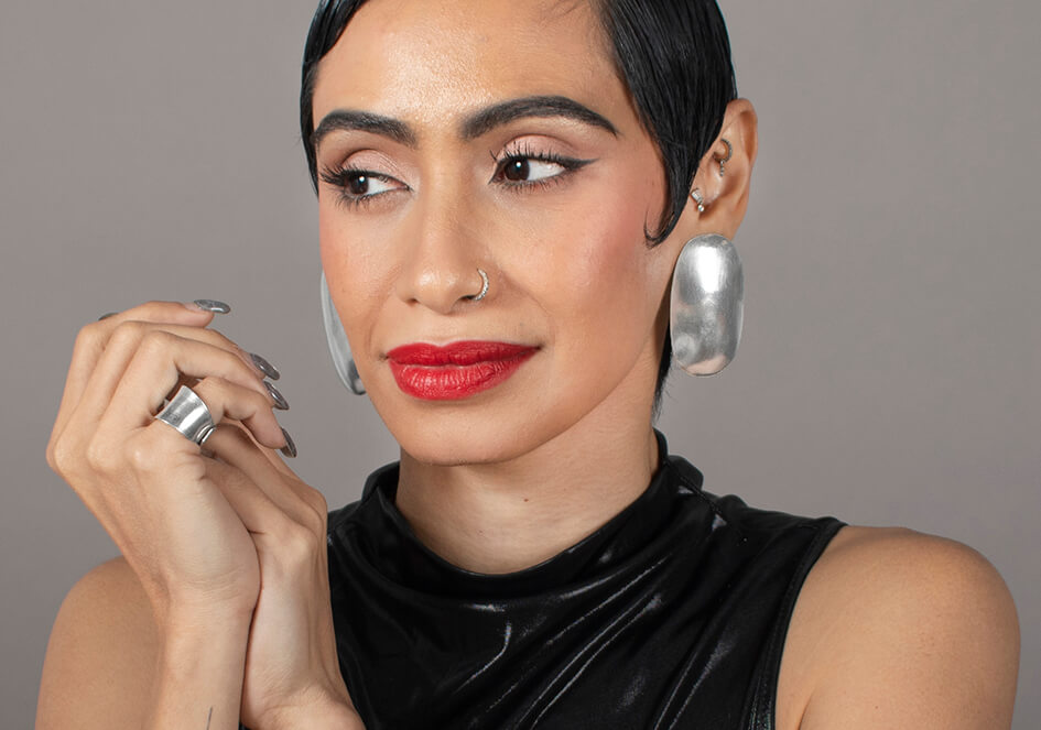 Model wearing a pair of large oval silver statement earrings from Hill to Street