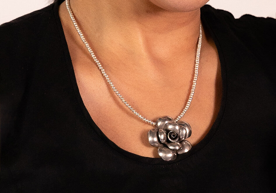 A model in black top wearing handmade pure silver medium size Mawar Rose pendant and pure silver beads necklace from Hill to Street Silver jewelry.