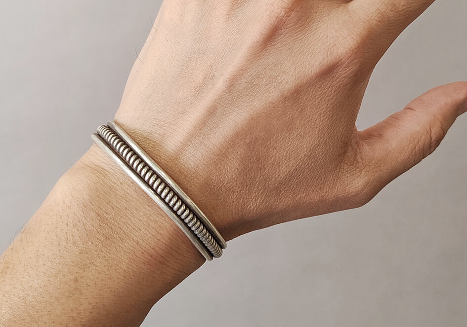 Model wearing The Kian Bangle, a handcrafted pure silver cuff inspired by traditional artisan techniques.