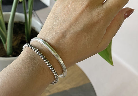 Model wearing The Lily Bangle, a minimalist pure silver bangle designed for everyday wear.
