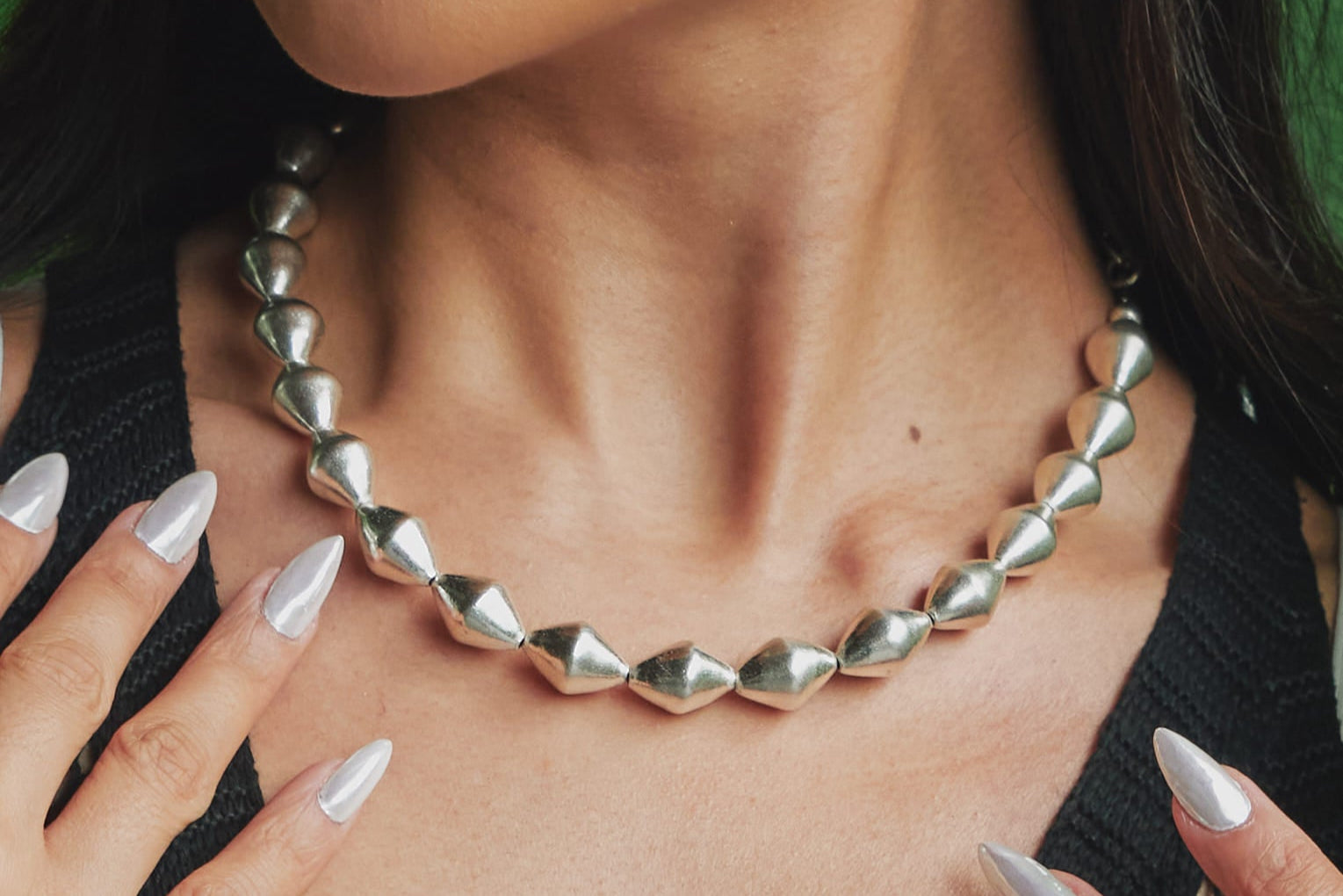 Rosemond Necklace worn at the neckline, styled simply to showcase its fluid, sculptural drape against bare skin