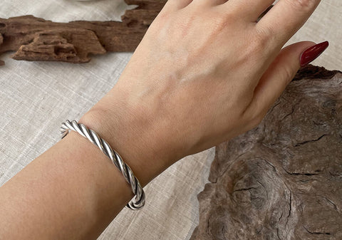 Model wearing Sofia Bangle, a classic pure silver twisted wire cuff bracelet for everyday styling.
