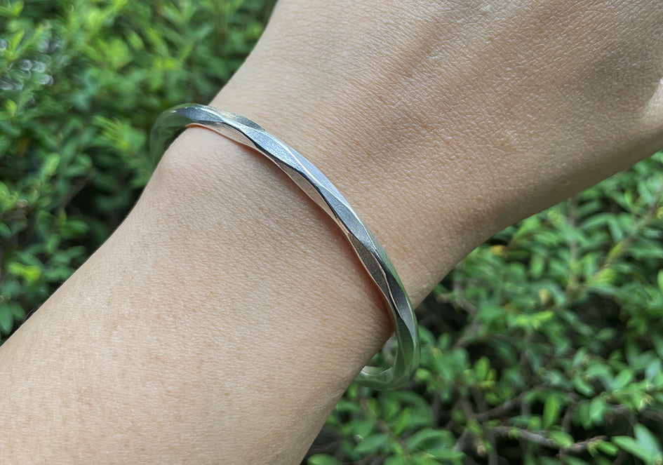 Model wearing Vera Bangle, a minimalist pure silver cuff bracelet for everyday styling.