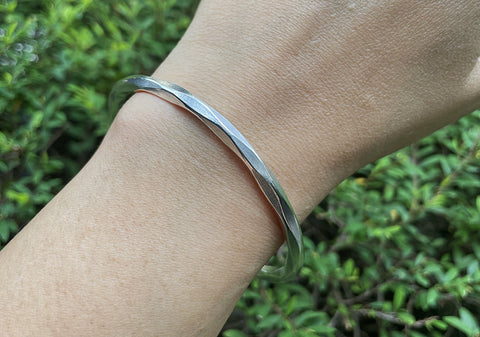 Model wearing Vera Bangle, a minimalist pure silver cuff bracelet for everyday styling.