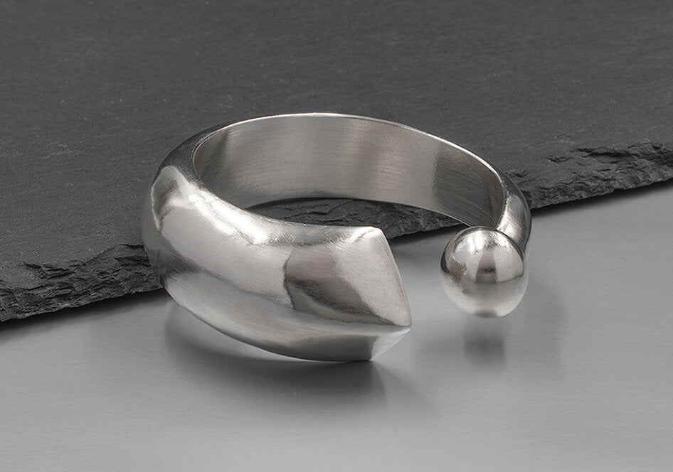 Close-up of the Apsara Bangle showing the sharp triangular tip and smooth rounded end on solid pure silver