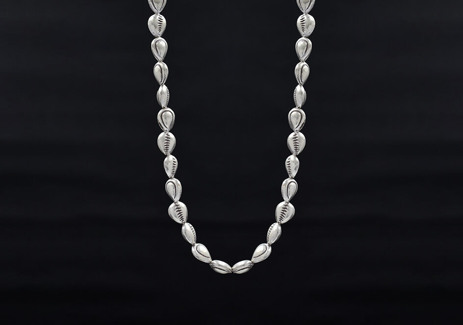 Close-up of pure silver shell beads and fish line stringing detail on the Harper Necklace