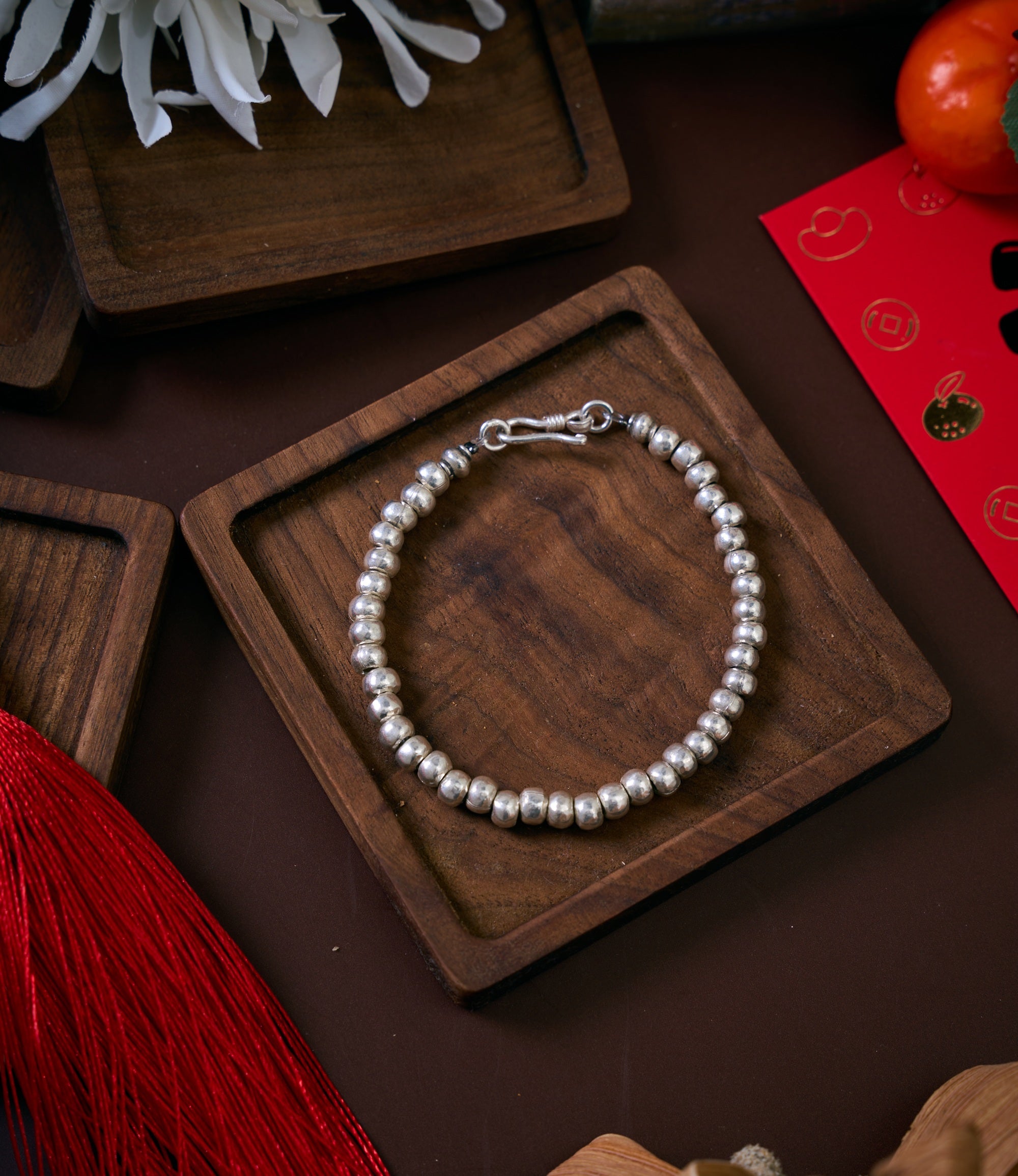 Anyi Bracelet in pure silver featuring large round silver beads, handcrafted bracelet laid flat on a clean surface