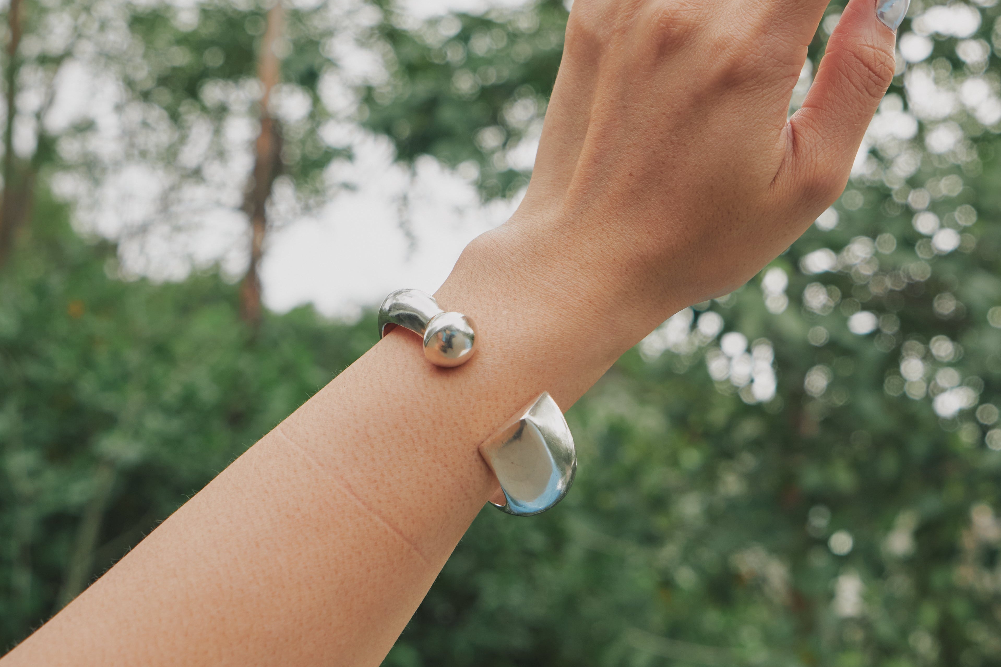 Apsara Bangle worn on wrist, styled as a standalone statement piece or stacked with other silver bangles.