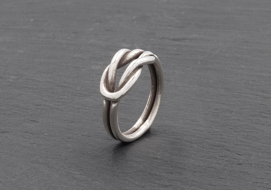 Close-up of the interlocked square knot on the Celine Knot Ring, showing two woven pure silver bands