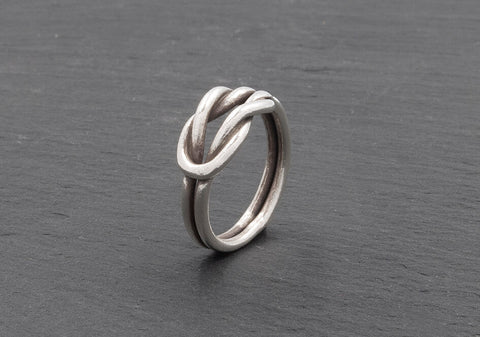 Close-up of the interlocked square knot on the Celine Knot Ring, showing two woven pure silver bands