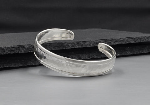 Close-up of hammered texture and side-wrapped detailing on the Lainey pure silver bangle