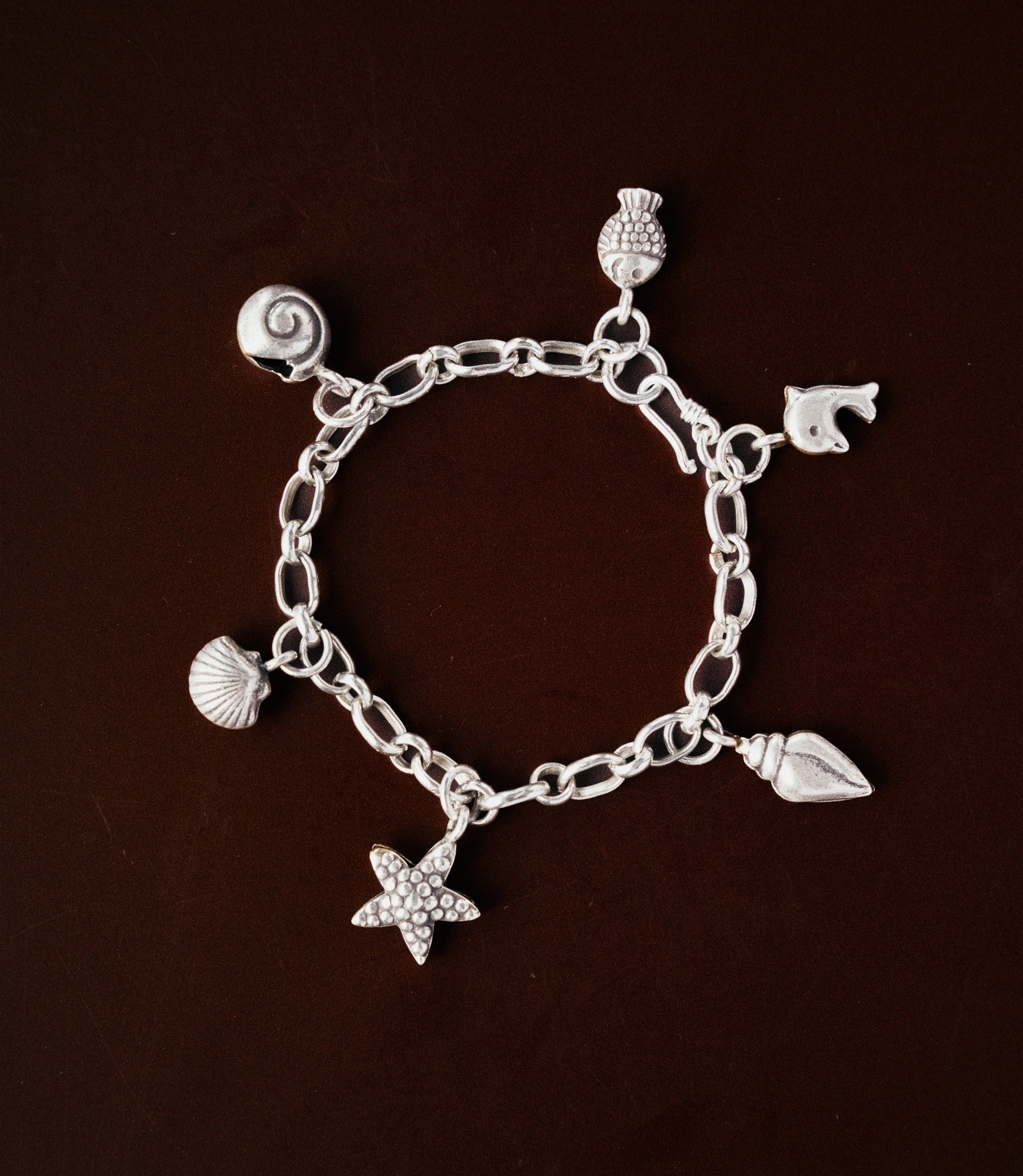 Model wearing the Maren Charm Bracelet, a pure silver charm bracelet with coastal-inspired details for everyday styling.
