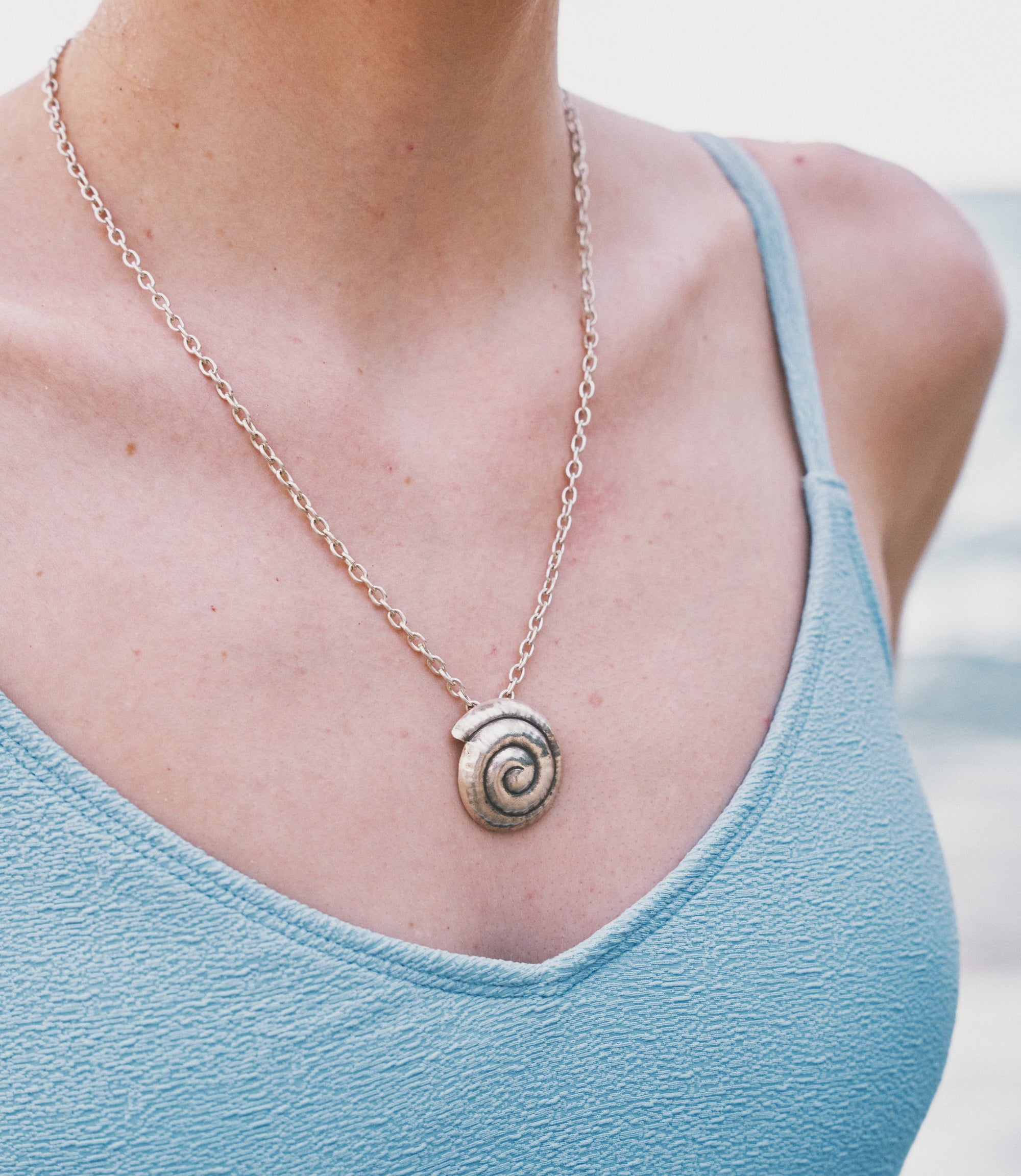 Model wearing the Nerida Necklace, a beach-inspired pure silver spiral pendant necklace for everyday styling.