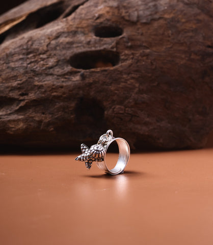 Nerina Charm Ring in pure silver with layered band and ocean charms, close-up of starfish and shell details