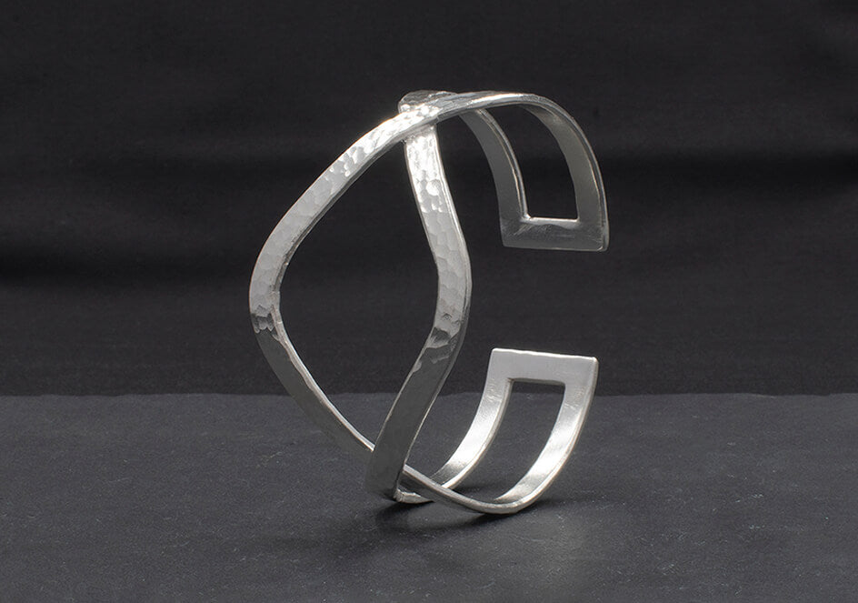 Close-up of hand-hammered pure silver surface on the Petra Cuff Bangle showing wave-inspired texture and light reflection