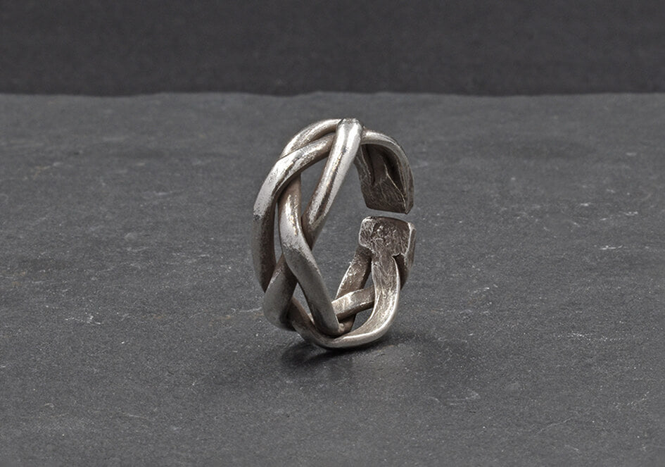 Close-up of Taylor Ring showing intricate twisted line detail and brushed pure silver finish.
