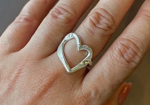 Handcrafted pure silver open heart ring by Hill to Street, photographed on slate surface