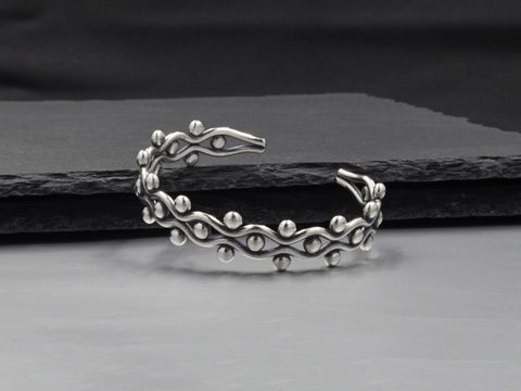 Close-up of Mariela Bangle showing fine dot-work, tribal motifs, and brushed pure silver finish.