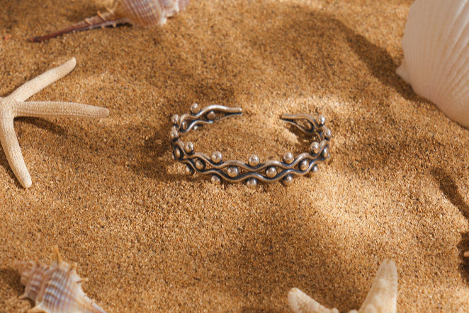 Openwork cuff with wave crests and vertical etched bars