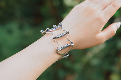 Model wearing The Gael Bangle, a handcrafted pure silver wave cuff bangle inspired by the ocean.