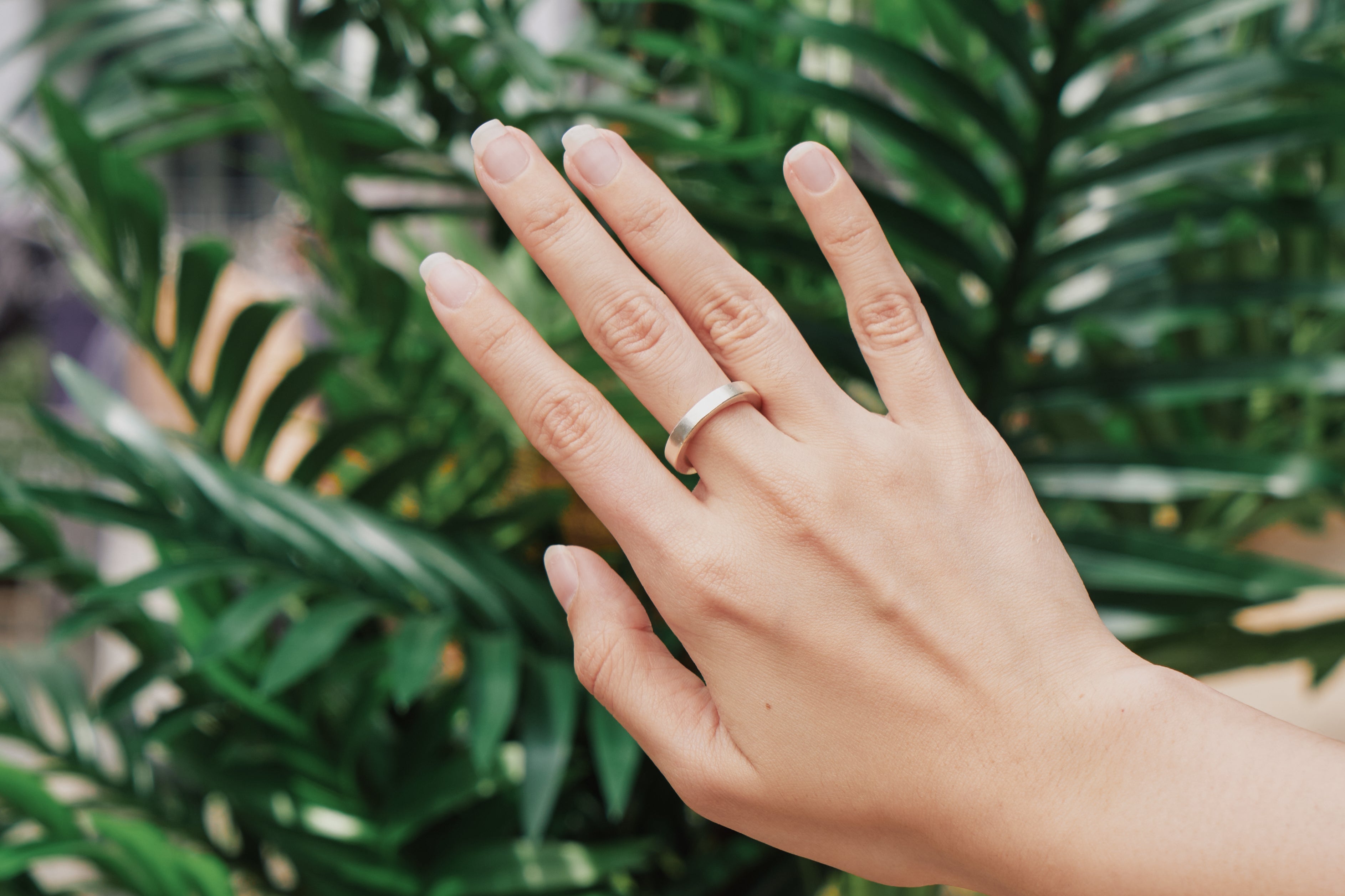 Aiden Band Ring worn on hand, stacked with other silver rings for a modern layered look