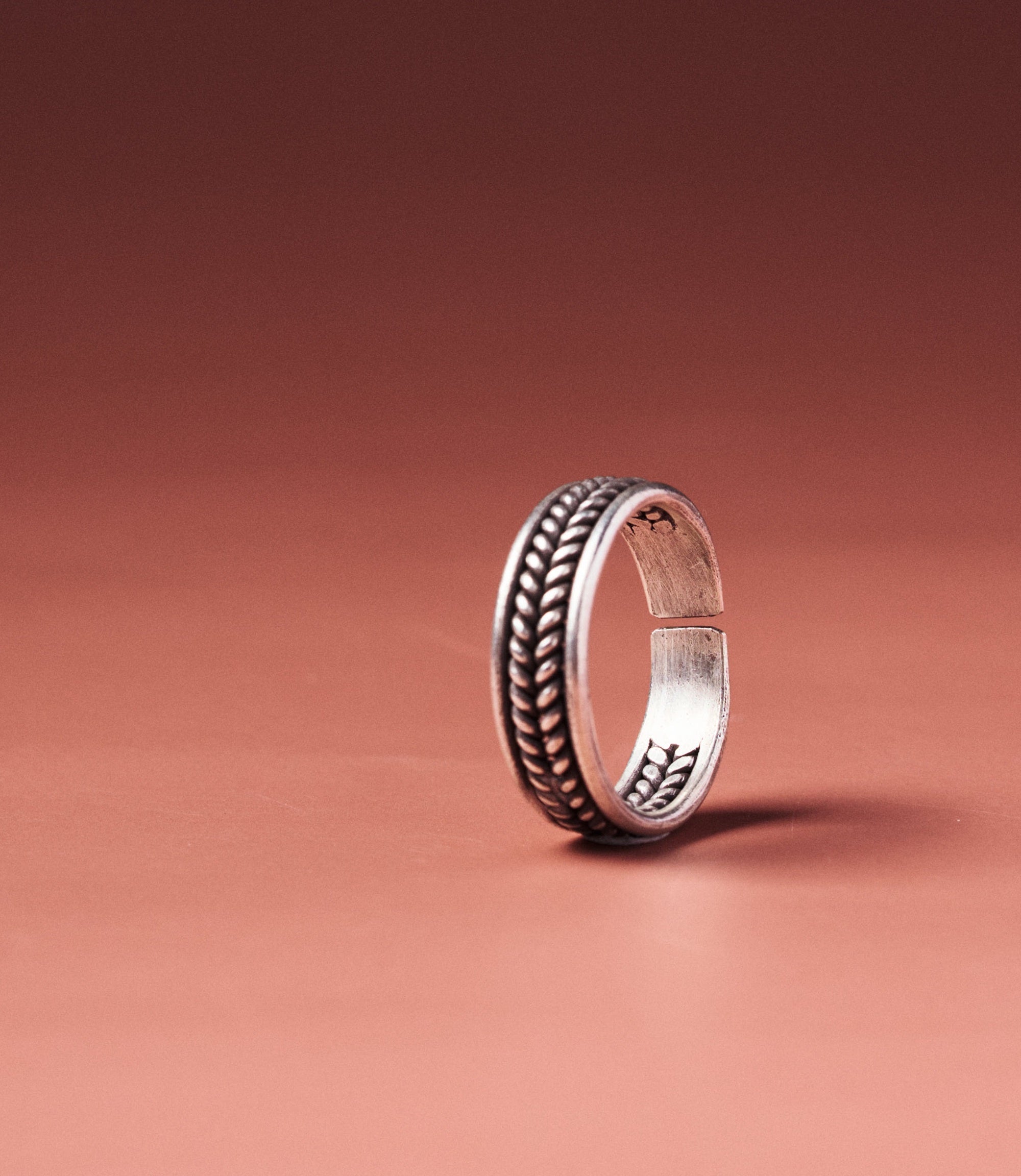 Alexis Ring in pure silver showing intertwined wire band and open adjustable design.