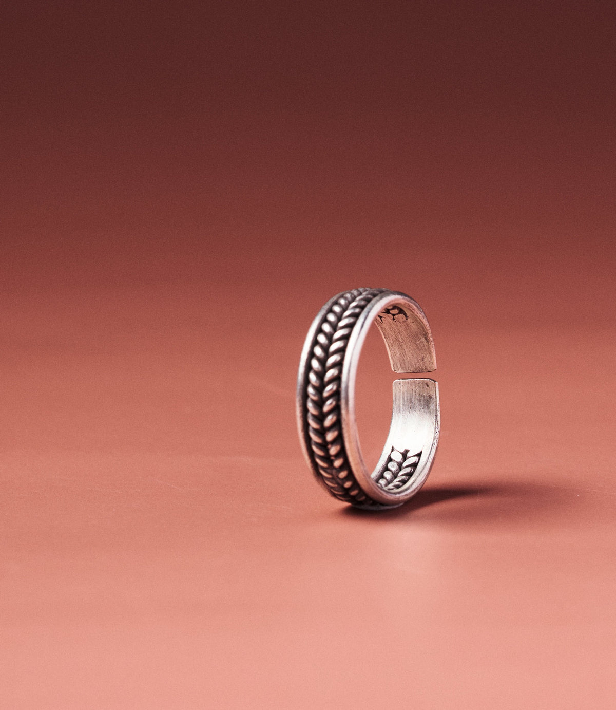 Alexis Ring in pure silver showing intertwined wire band and open adjustable design.