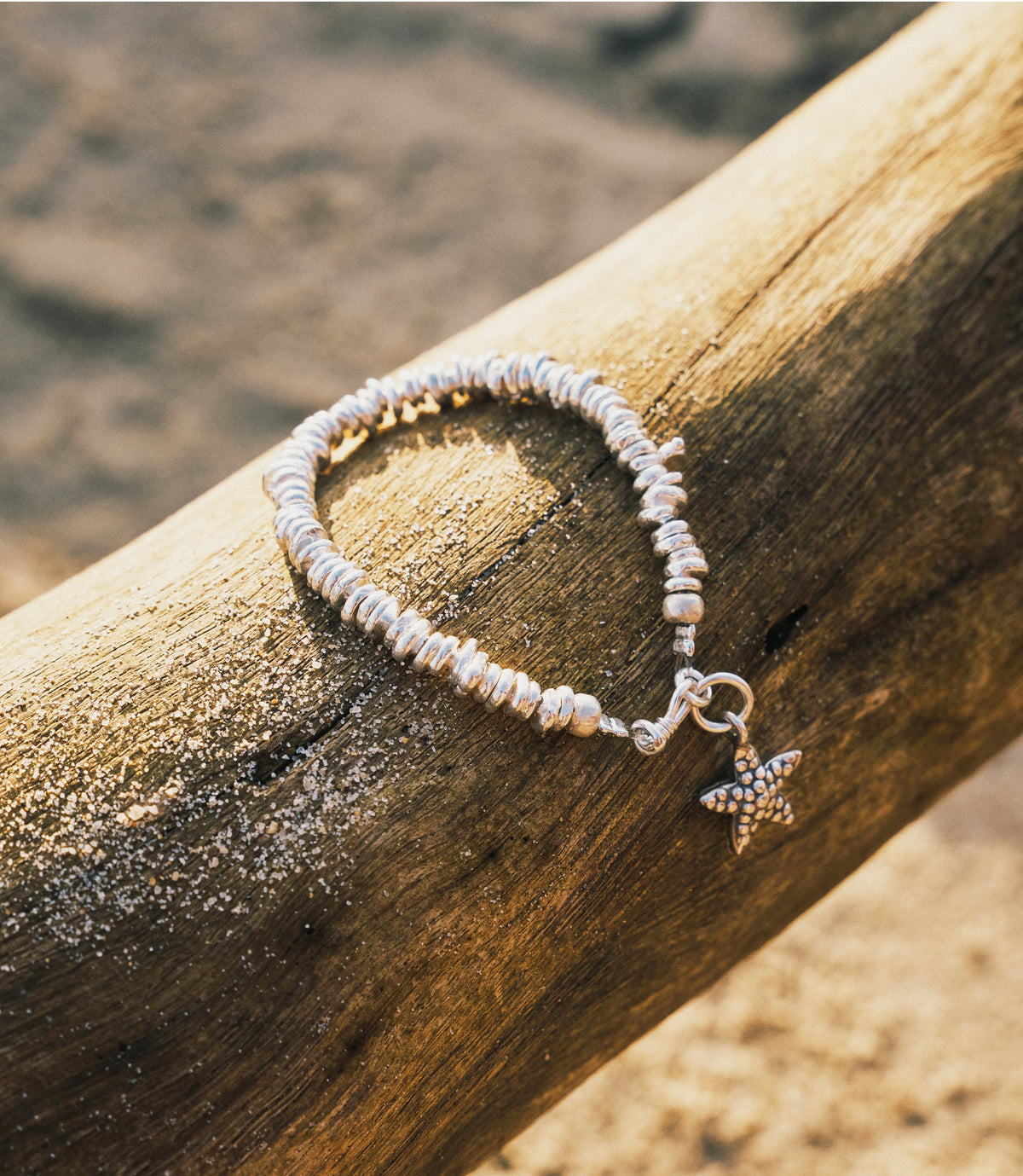 The Cora Bracelet in pure silver featuring handcrafted irregular silver beads with a starfish charm.