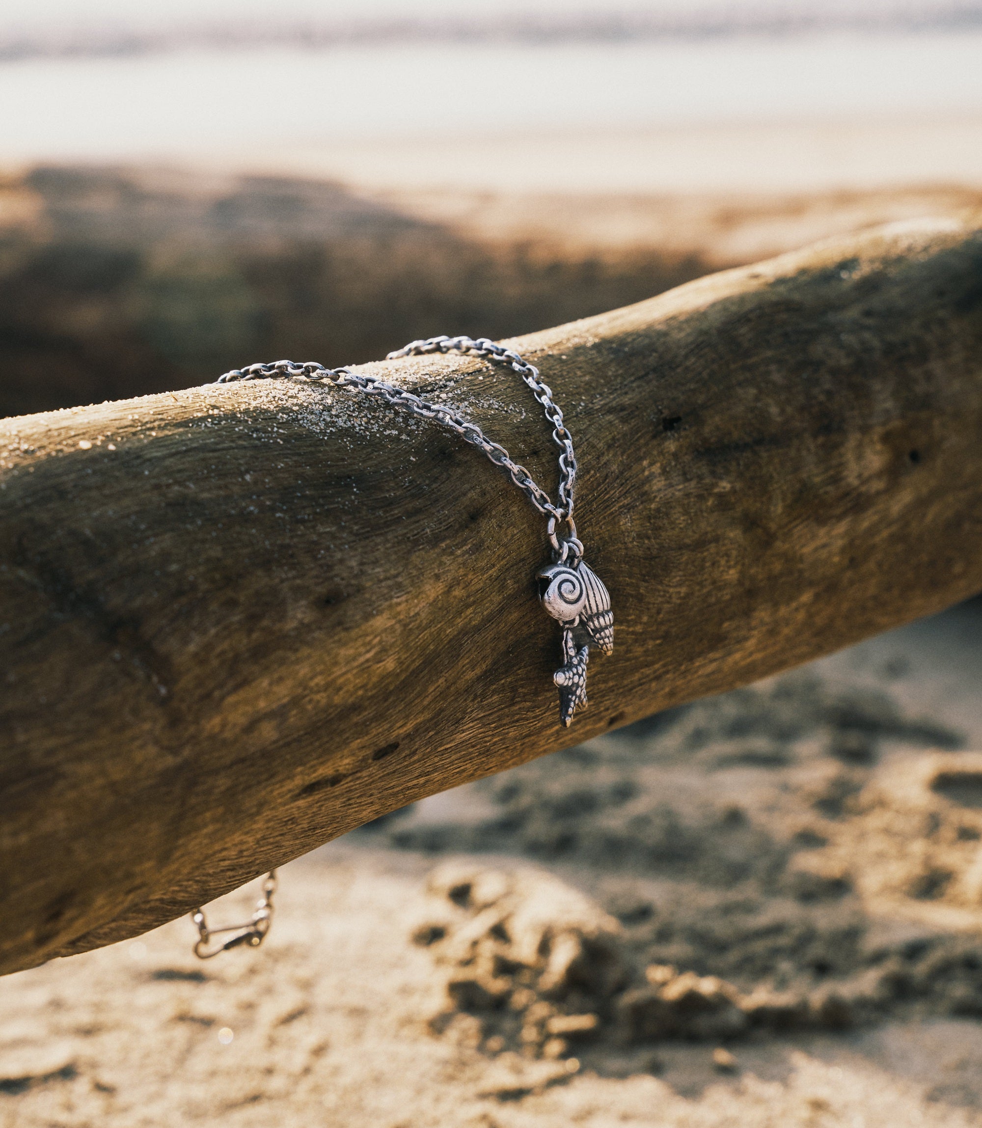 Detailed view of The Marina Charm Necklace featuring coastal-inspired silver seashell and starfish charms.