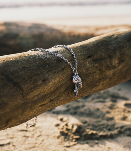 Detailed view of The Marina Charm Necklace featuring coastal-inspired silver seashell and starfish charms.