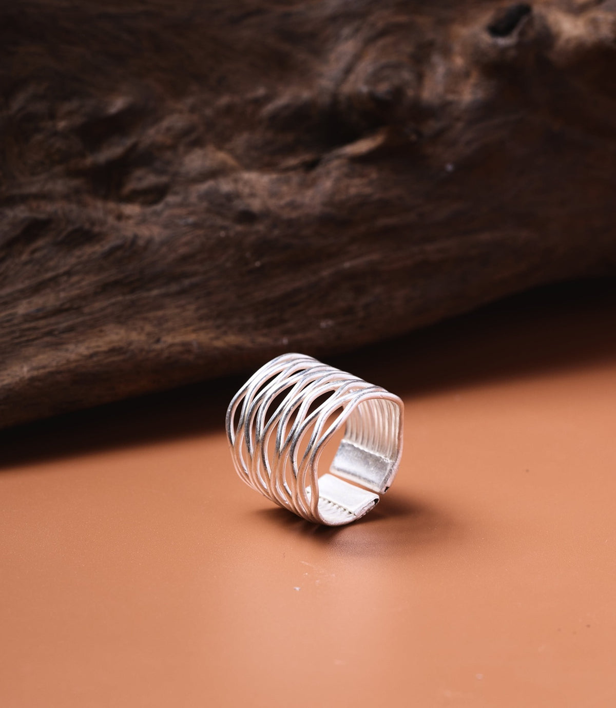 The Giselle Ring in pure silver featuring a wide band with graceful interwoven curves.