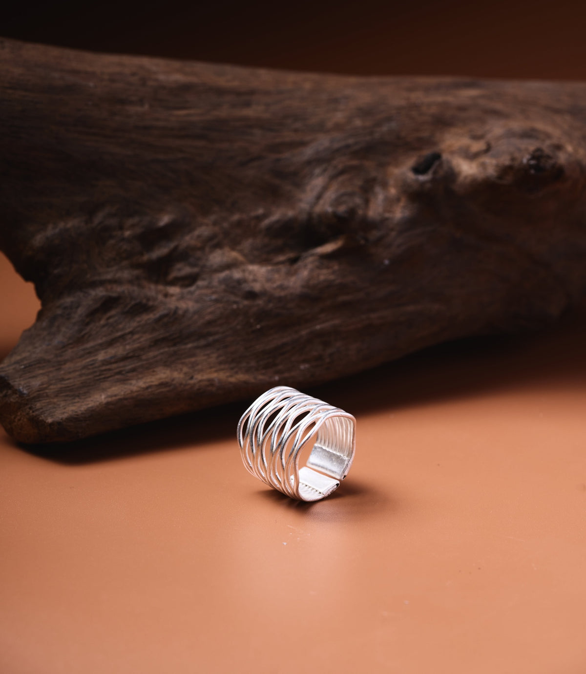 The Giselle Ring in pure silver featuring a wide band with graceful interwoven curves.