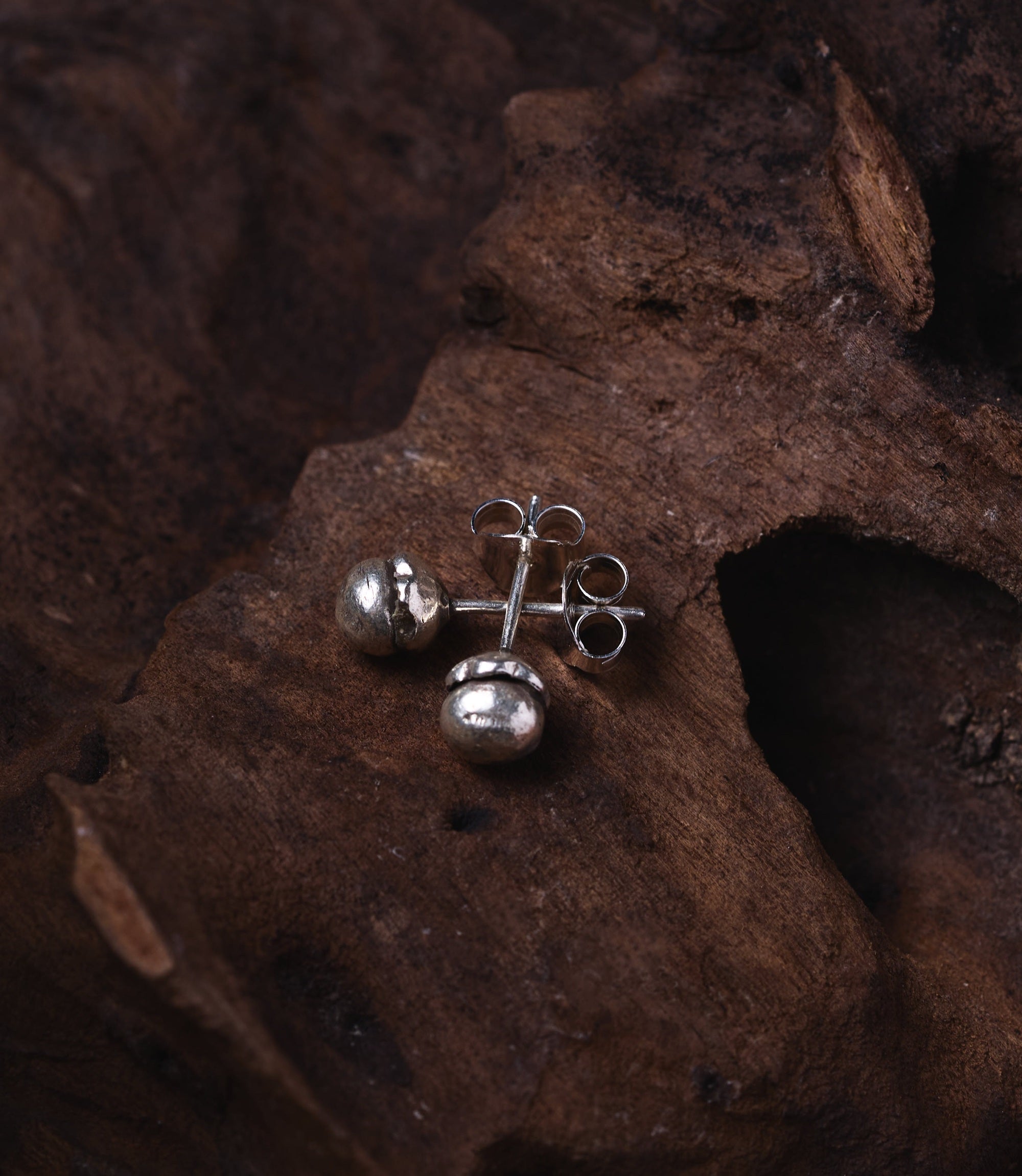 Minimalist pure silver flower bud studs worn as everyday earrings for a clean, elegant look